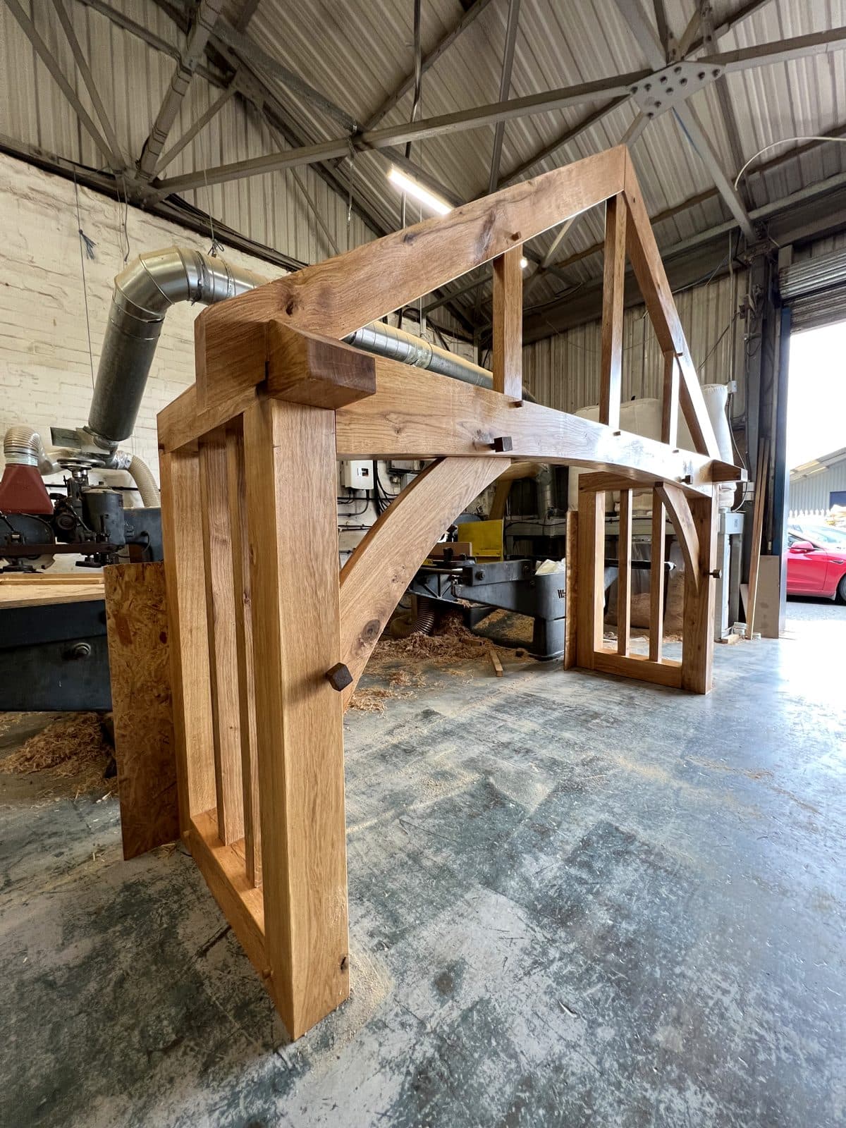 Ludlow porch frame in build — curved brace meeting post and beam